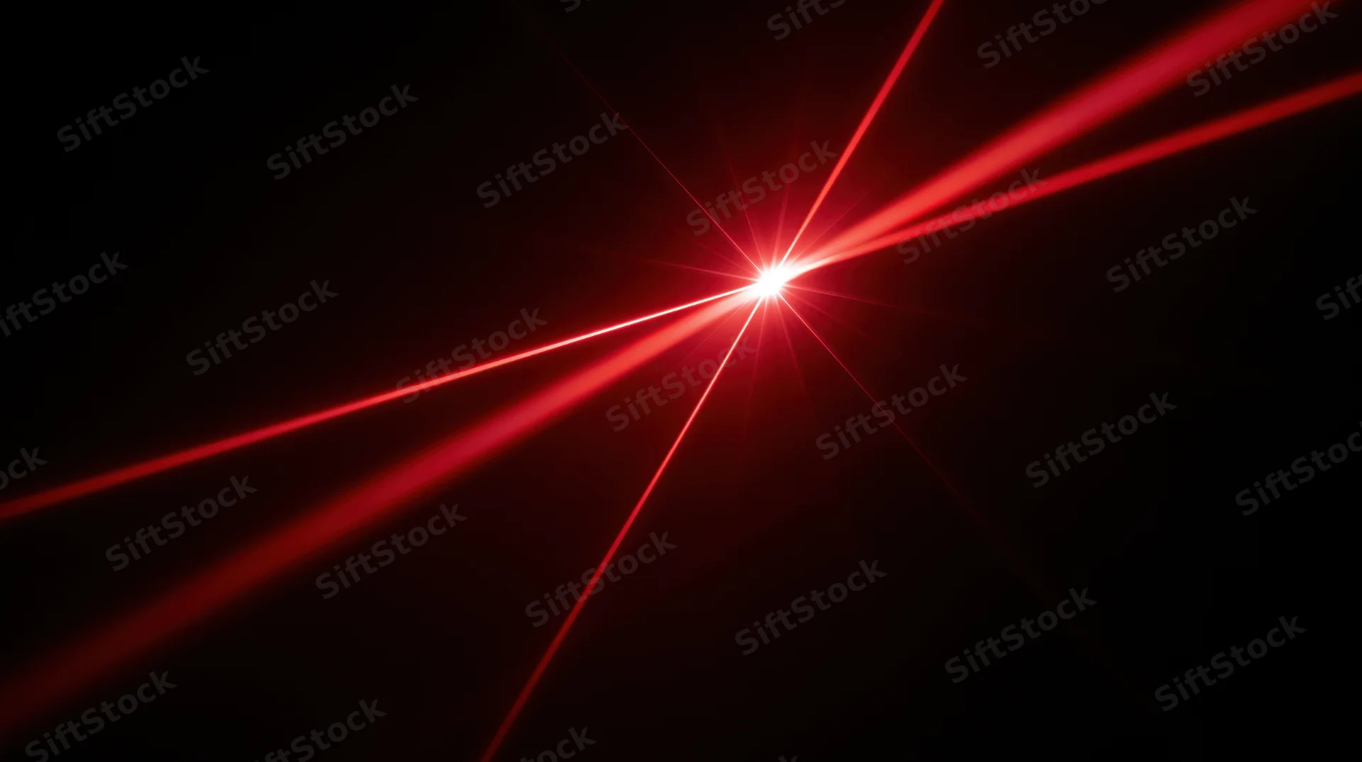 Red laser beams converging at a bright focal point in darkness
