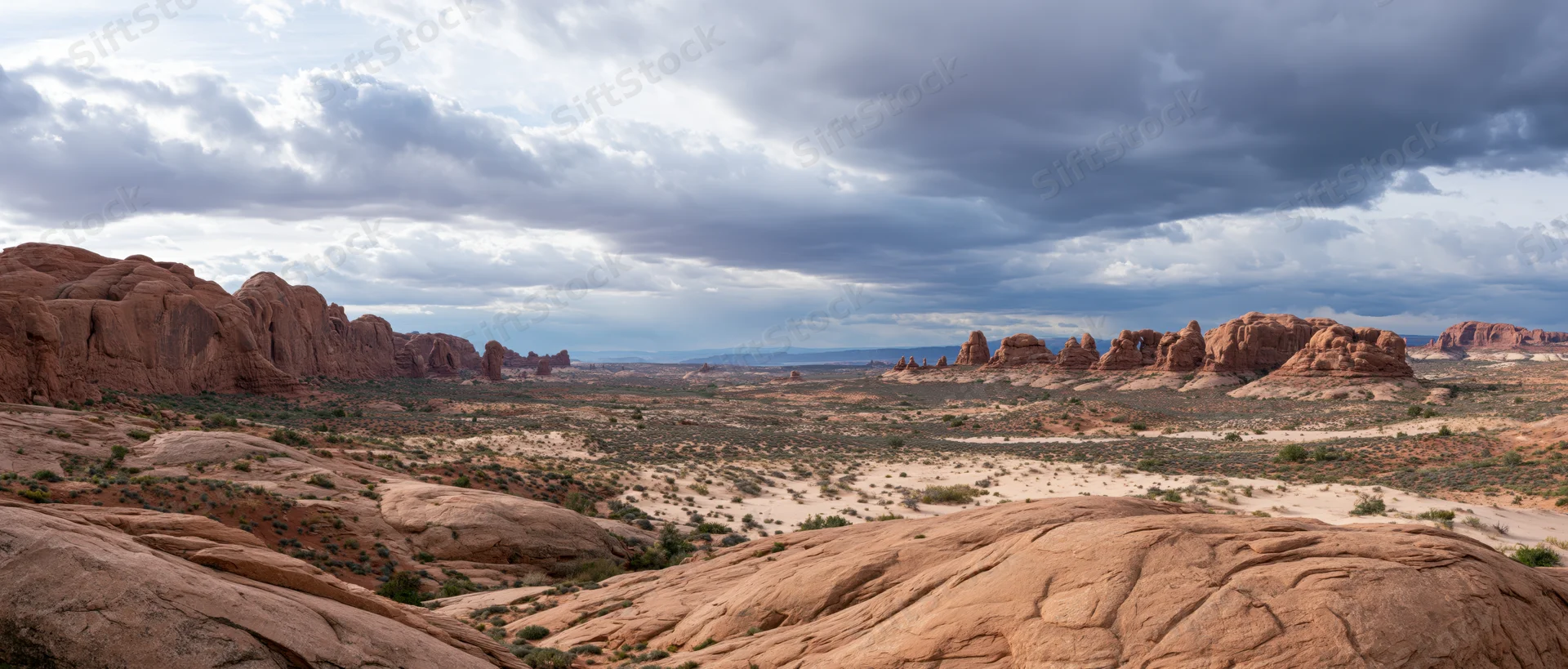 Red rock formations in a desert landscape under cloudy sky