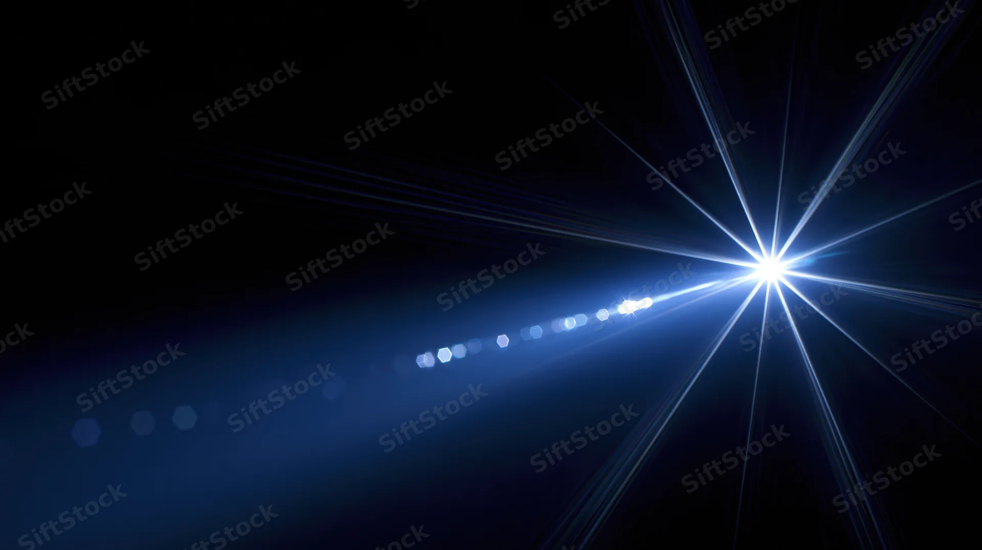 Bright blue starburst light flare with lens flare and bokeh circles on dark background