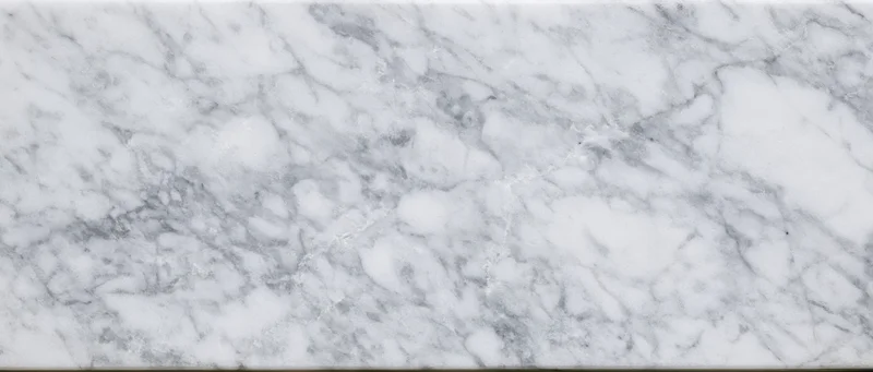 Close-up of white marble slab with gray veining, used for interior surfaces