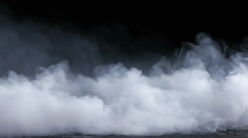 Swirling white smoke rising from a dark surface against a black background