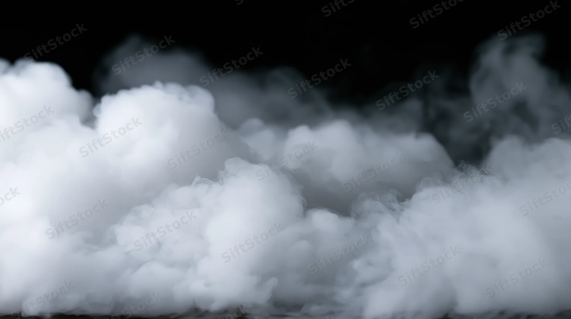 White smoke billowing across a black background in a studio setting