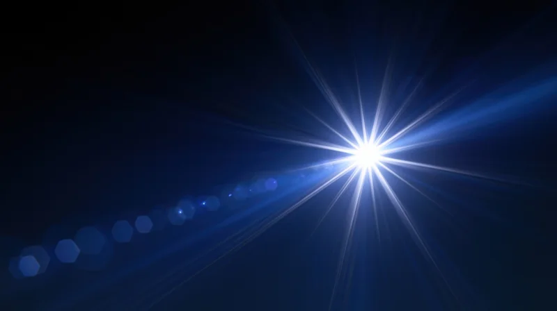 Bright starburst light flare with blue gradient and hexagonal bokeh in dark abstract background