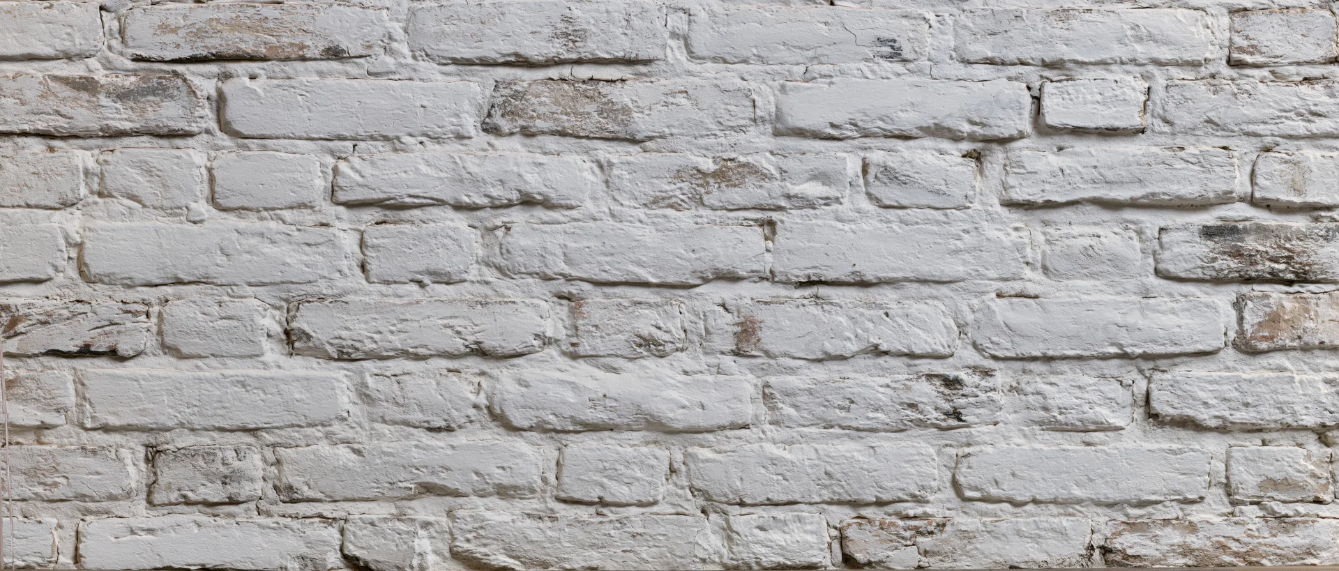 White painted brick wall with weathered texture and visible mortar joints