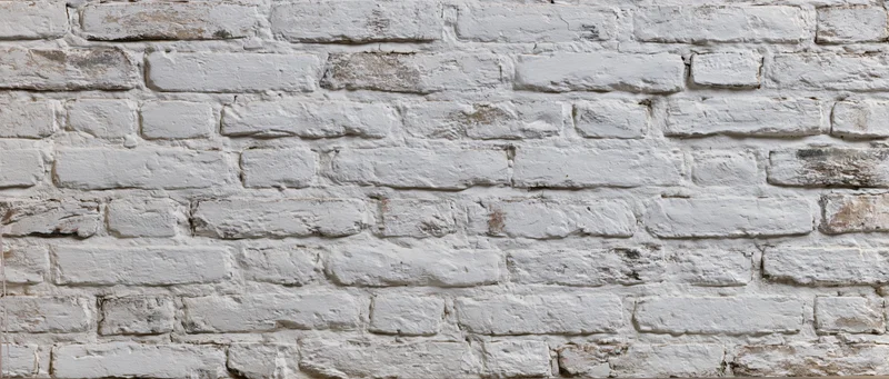 White painted brick wall with weathered texture and visible mortar joints