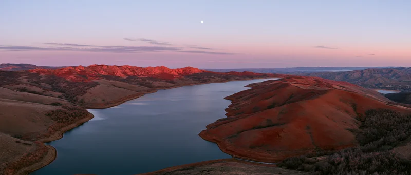 Red rock canyon with a calm lake at sunset, aerial view