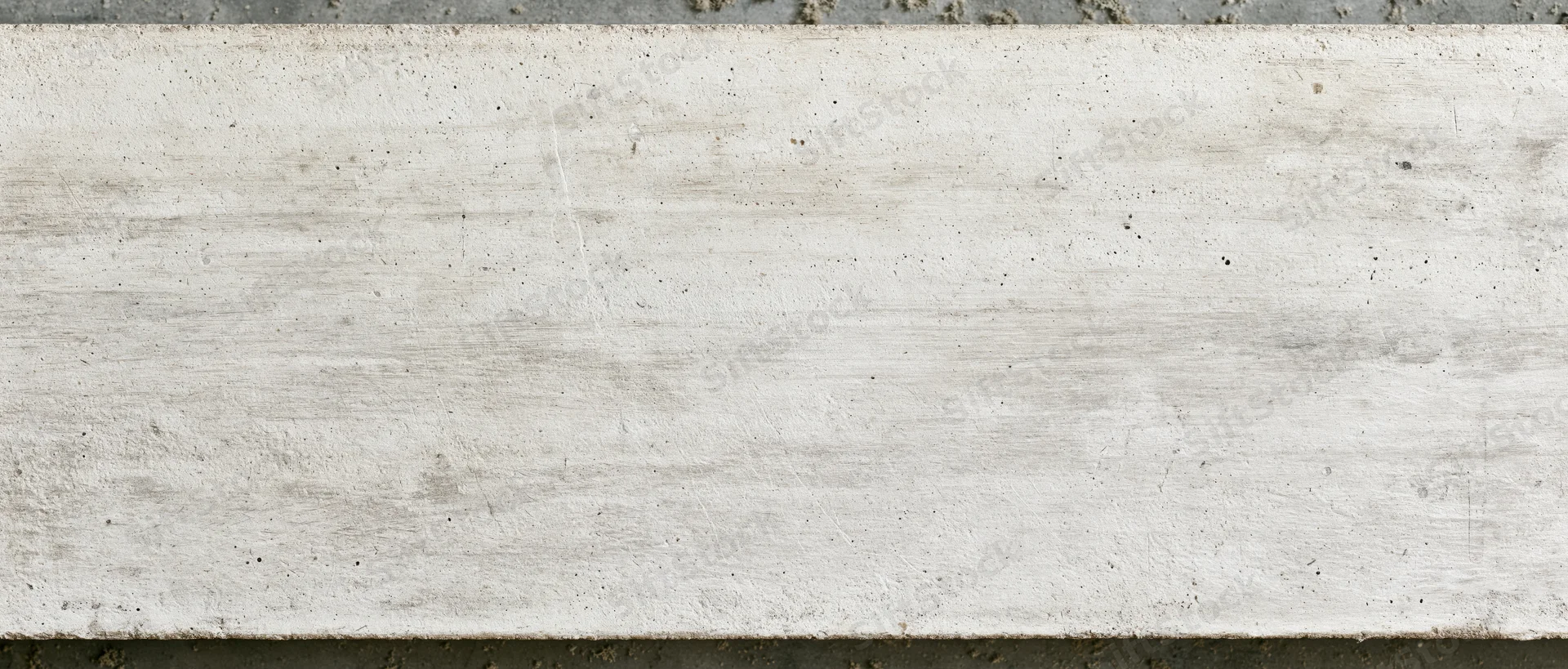 Horizontal concrete slab with textured surface and visible grain, framed by dark edges at top and bottom