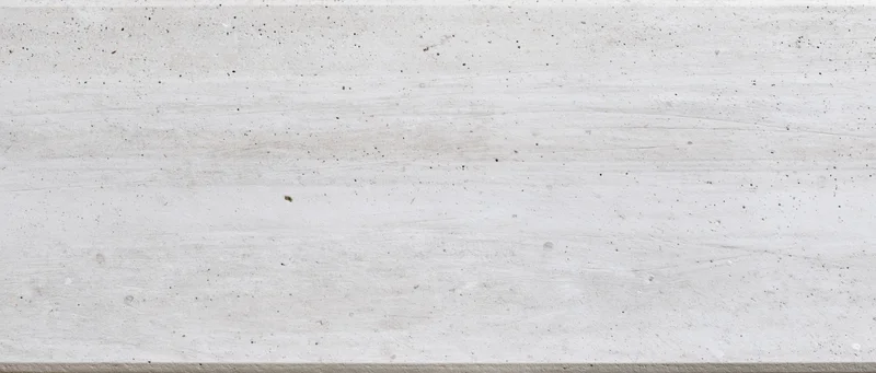 Closeup of a white veined marble surface with natural speckles and grain, used as a background for interior design