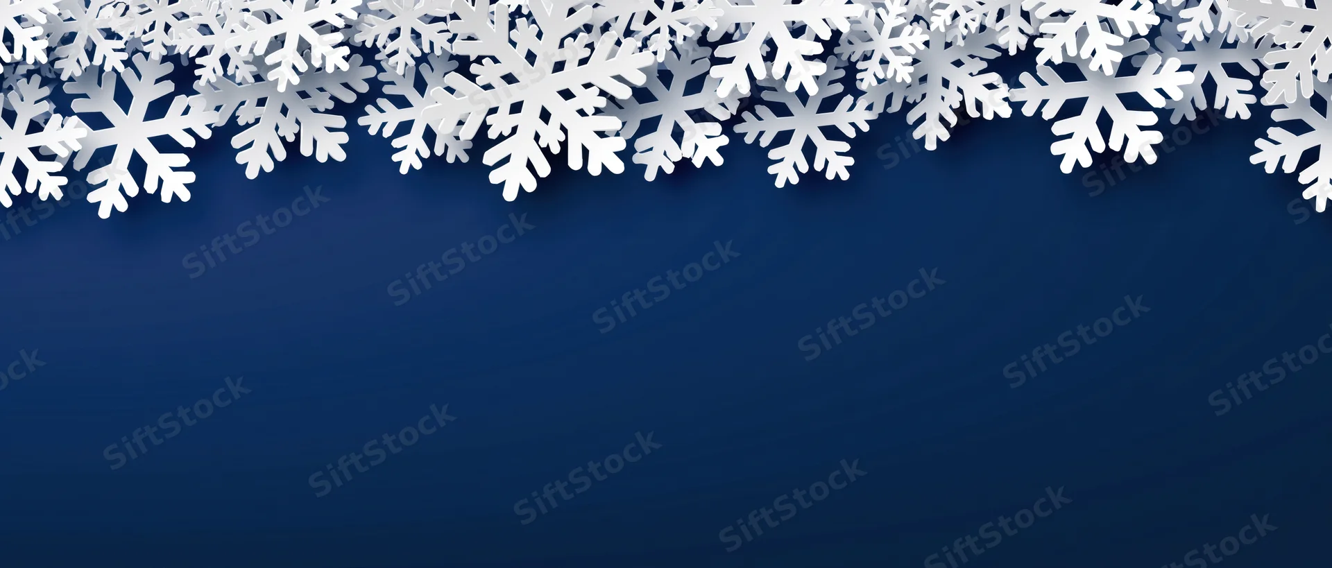 White snowflakes arranged as a decorative border along the top of a solid blue background with copyspace below