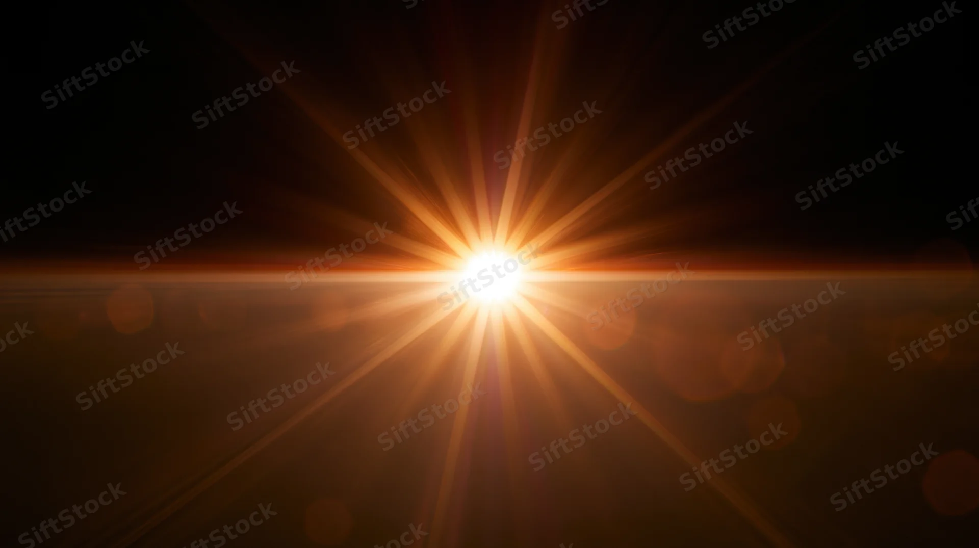 Bright sunburst radiating golden light across dark background with lens flare and bokeh effects