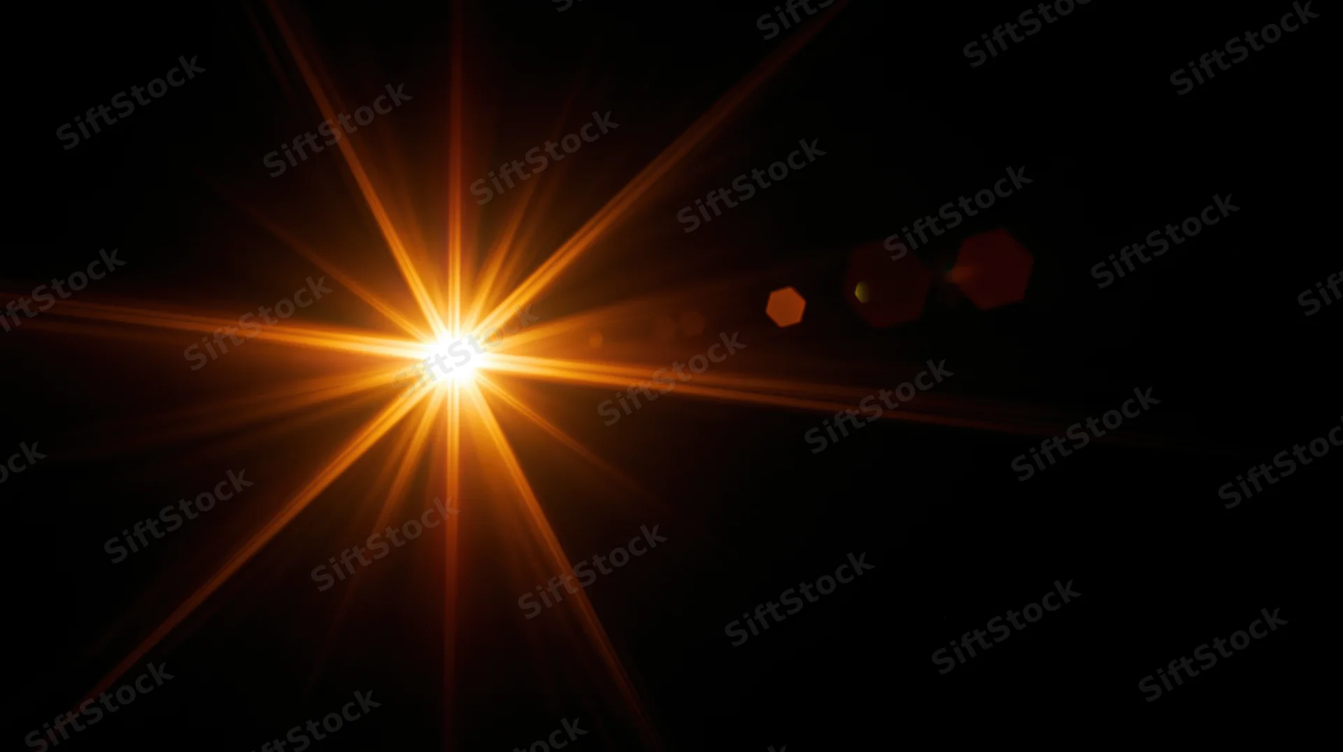 Bright orange starburst light flare on black background with lens flare artifacts
