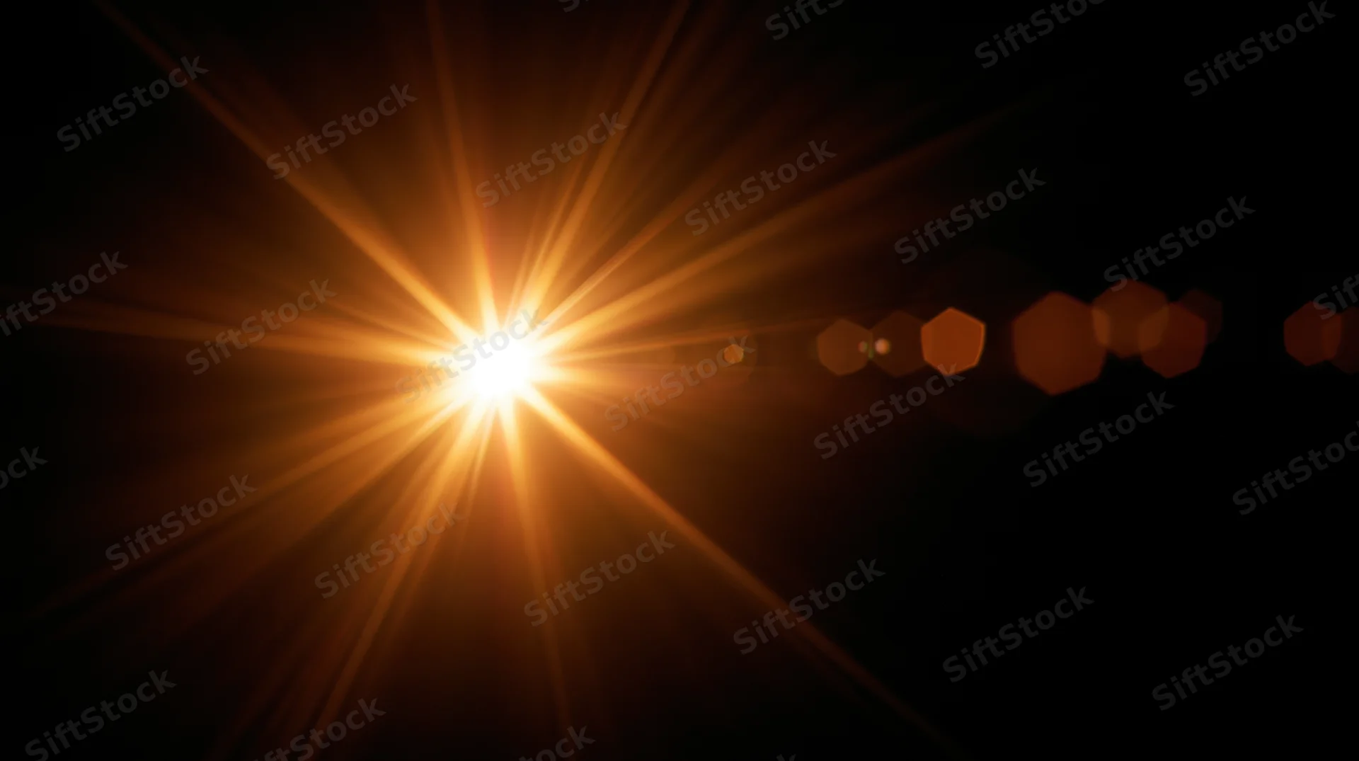 Bright golden light burst with lens flare and hexagonal bokeh against dark background