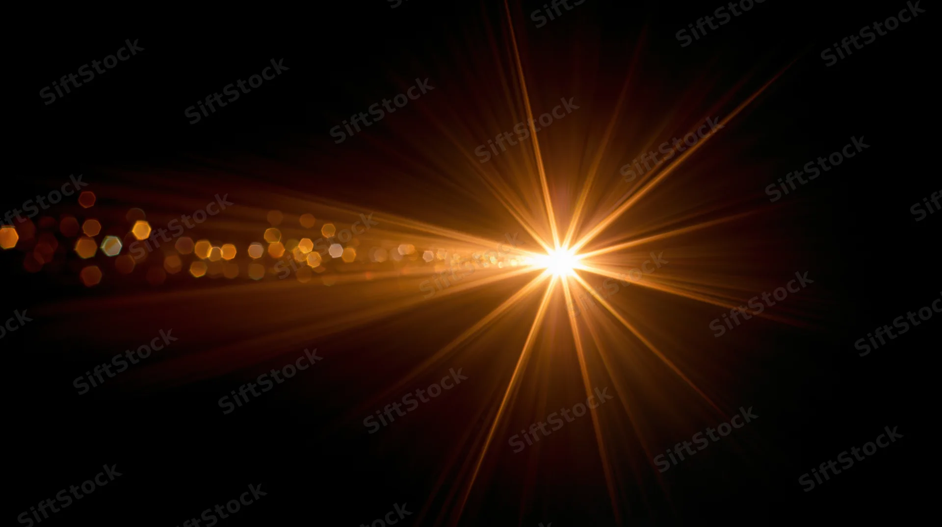 Bright golden light burst radiating from center against dark background with bokeh lights and copyspace