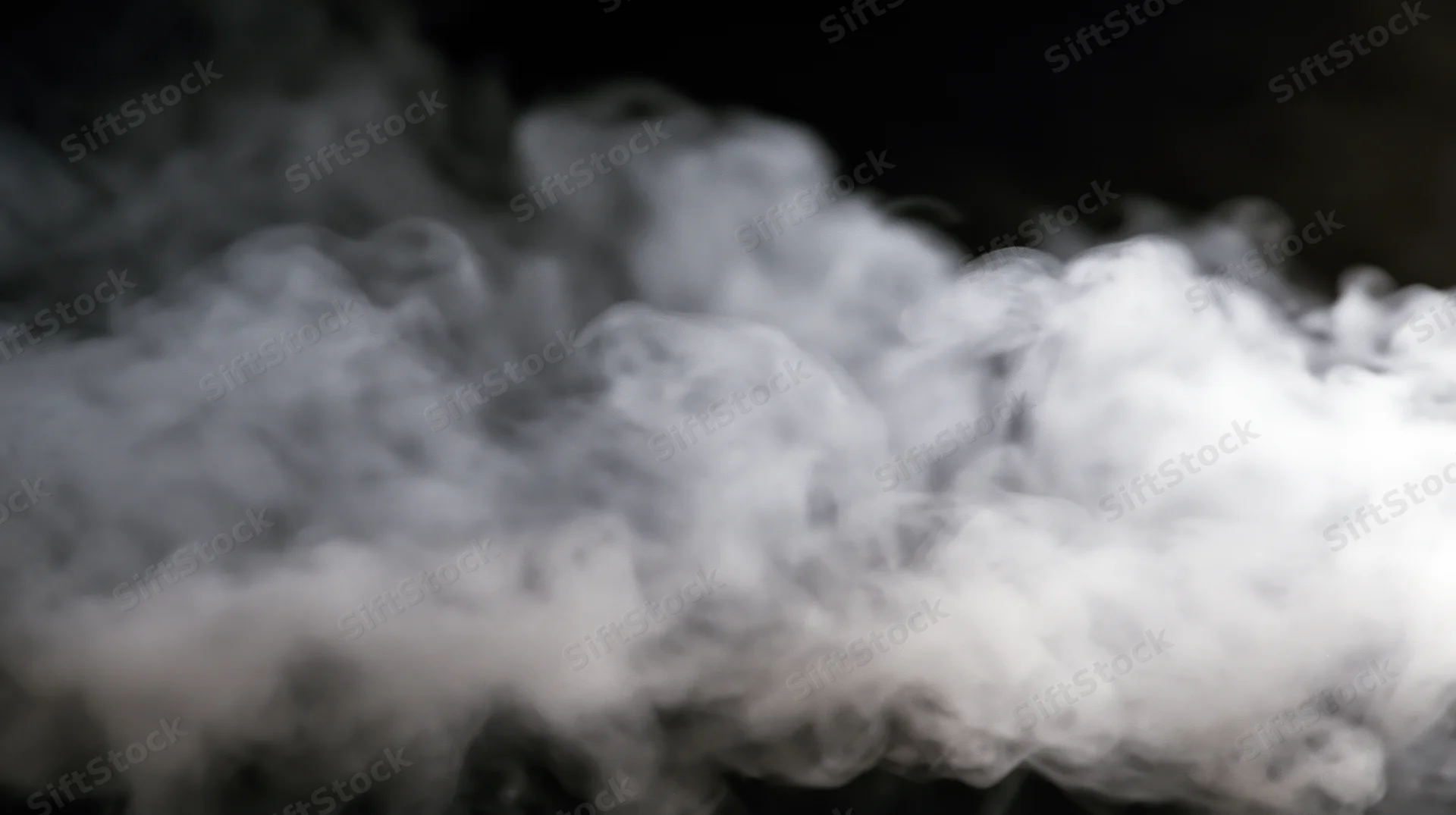 Swirling white smoke billowing against a dark background