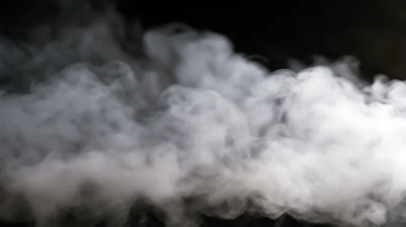 Swirling white smoke billowing against a dark background