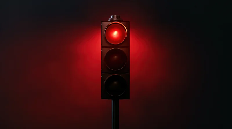 Vertical traffic light with red signal illuminated against dark background