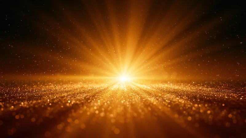Radiant golden light bursting from horizon over sparkling particles