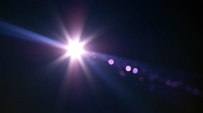 Bright light source with starburst flare and purple bokeh against dark background