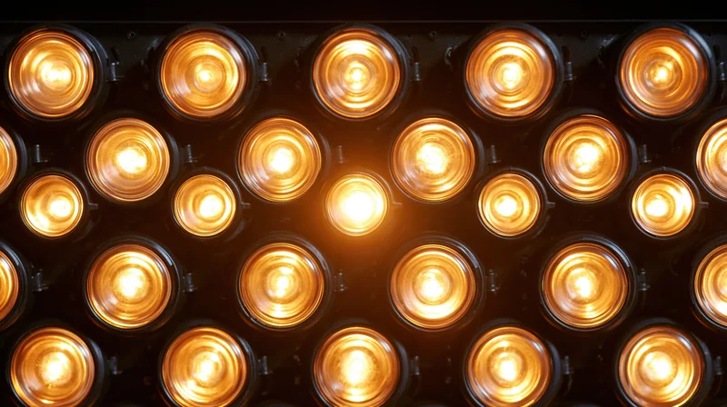 Grid of illuminated lightbulbs arranged in rows on a dark panel