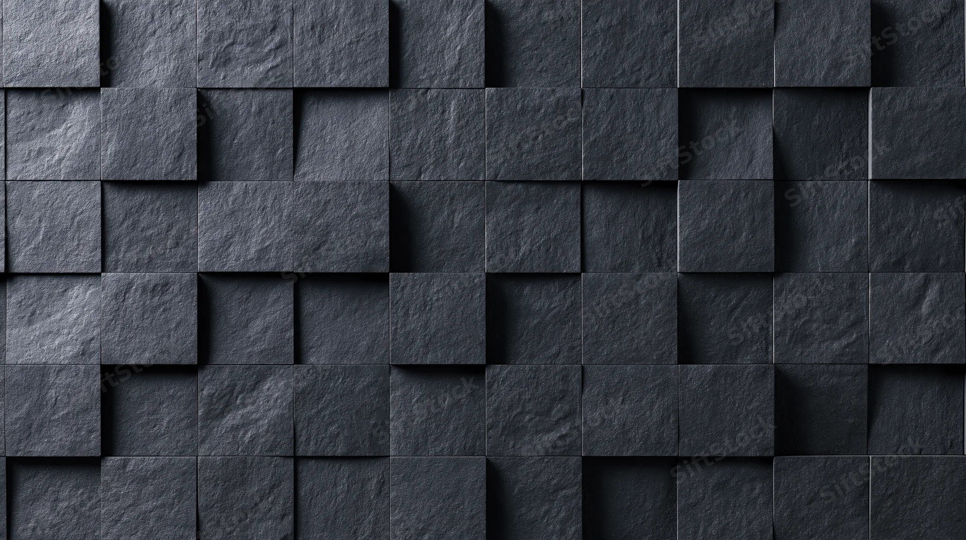 Black stone tiles arranged in a geometric pattern on a wall surface