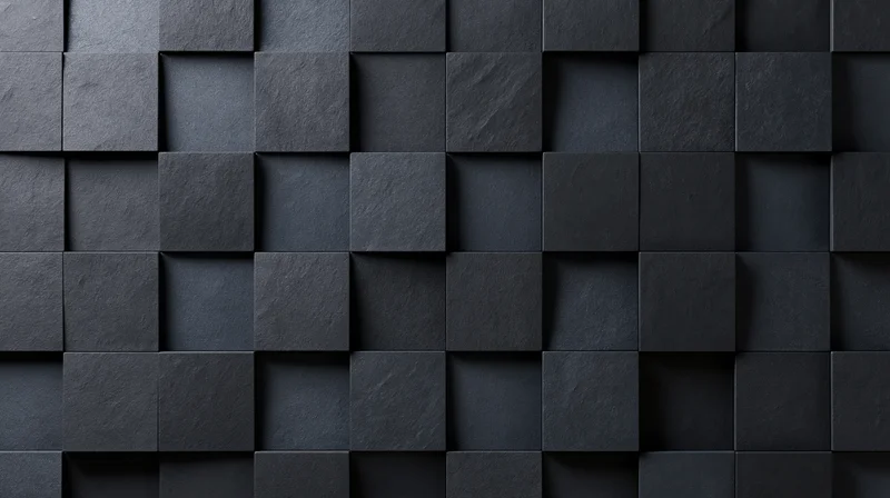 Dark geometric pattern of raised black squares arranged in a grid on a textured wall