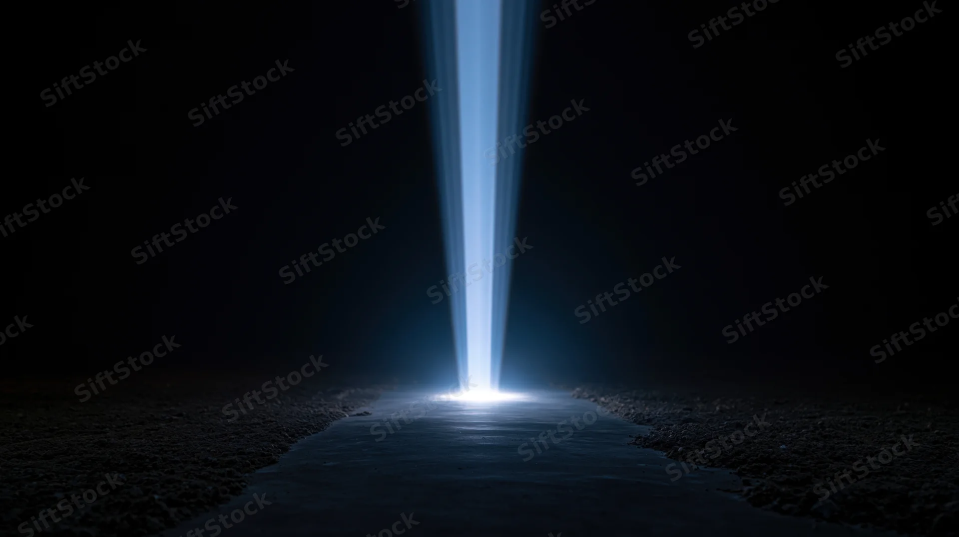 A bright blue light beam shining down onto a dark path at night