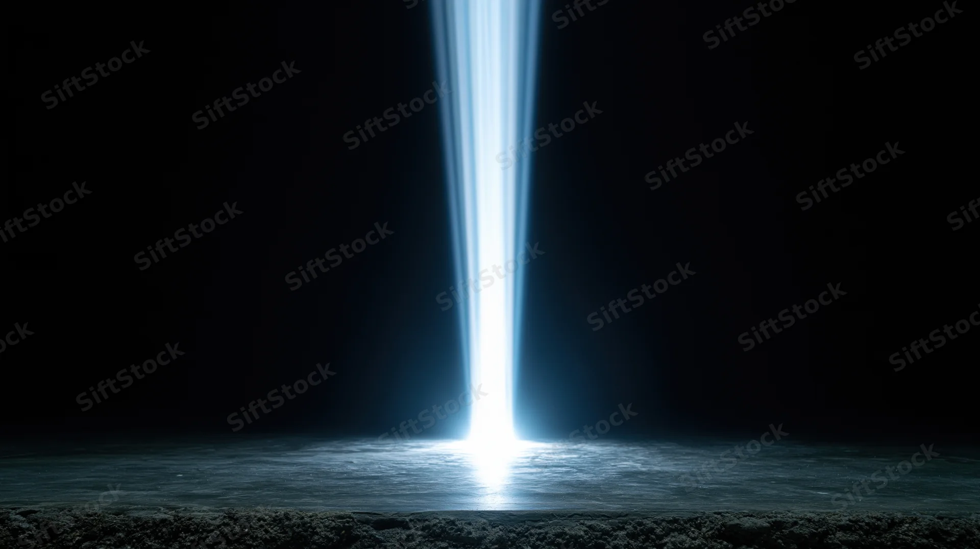 Vertical beam of bright blue light shining down onto a dark reflective surface