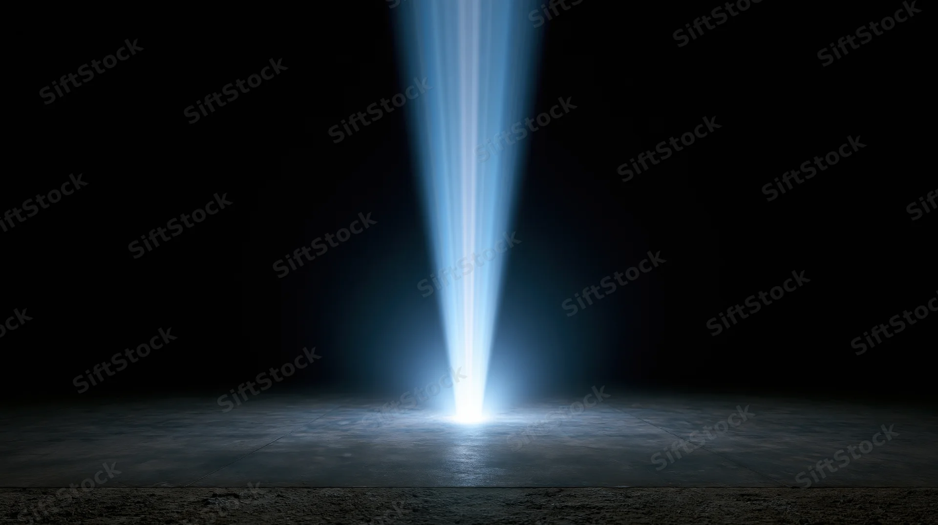 Vertical blue light beam shining down on dark concrete floor in empty studio space