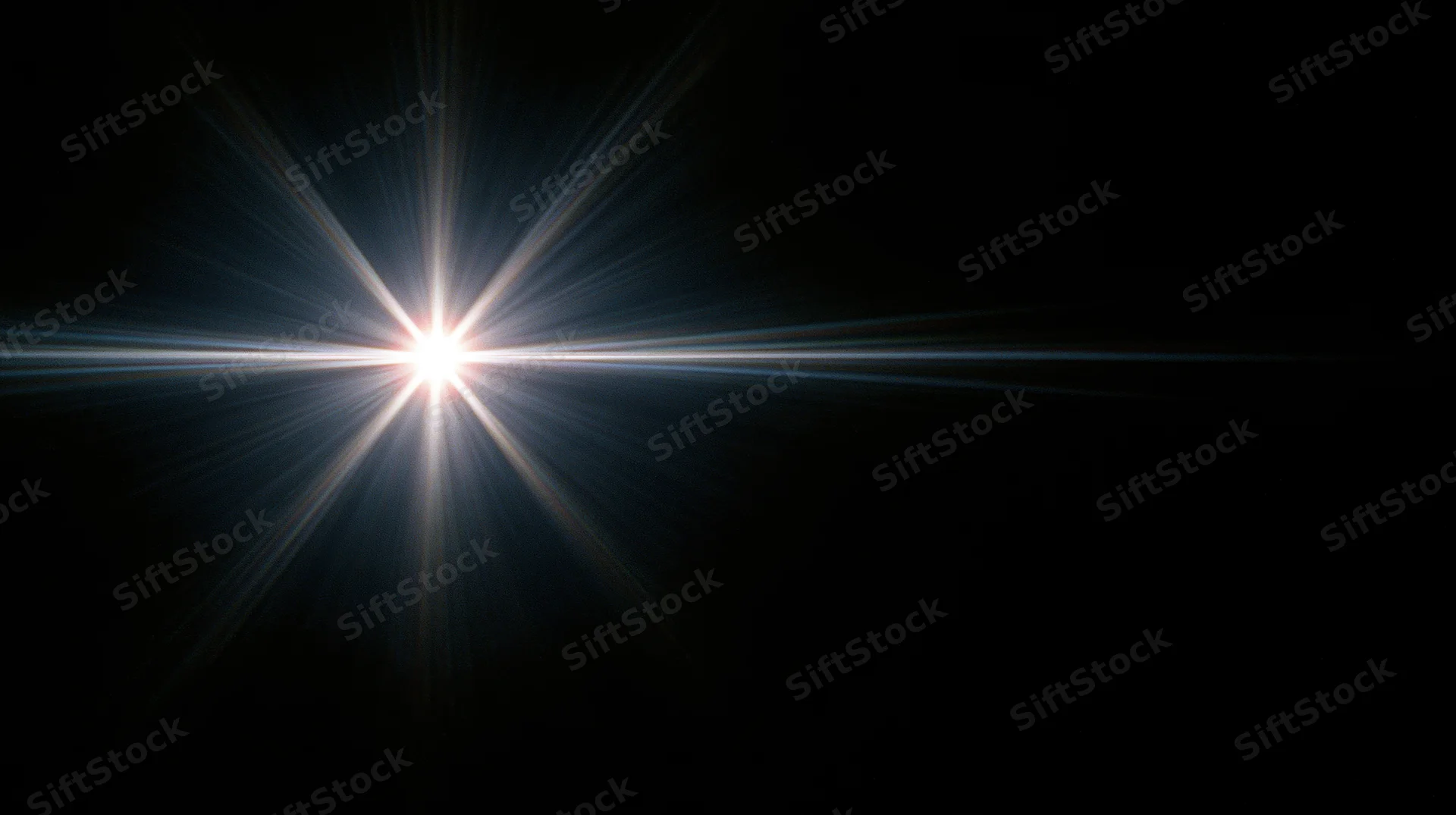 Bright starburst light flare radiating from center against dark background with copyspace