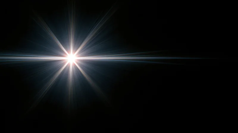 Bright starburst light flare radiating from center against dark background with copyspace