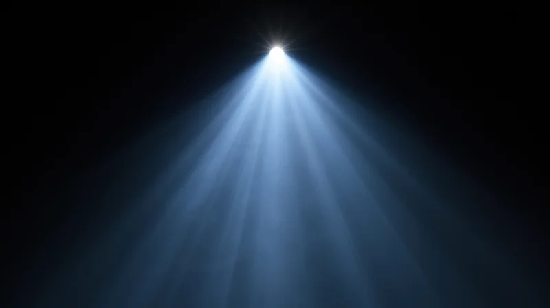 Spotlight beam shining down from above in a dark space