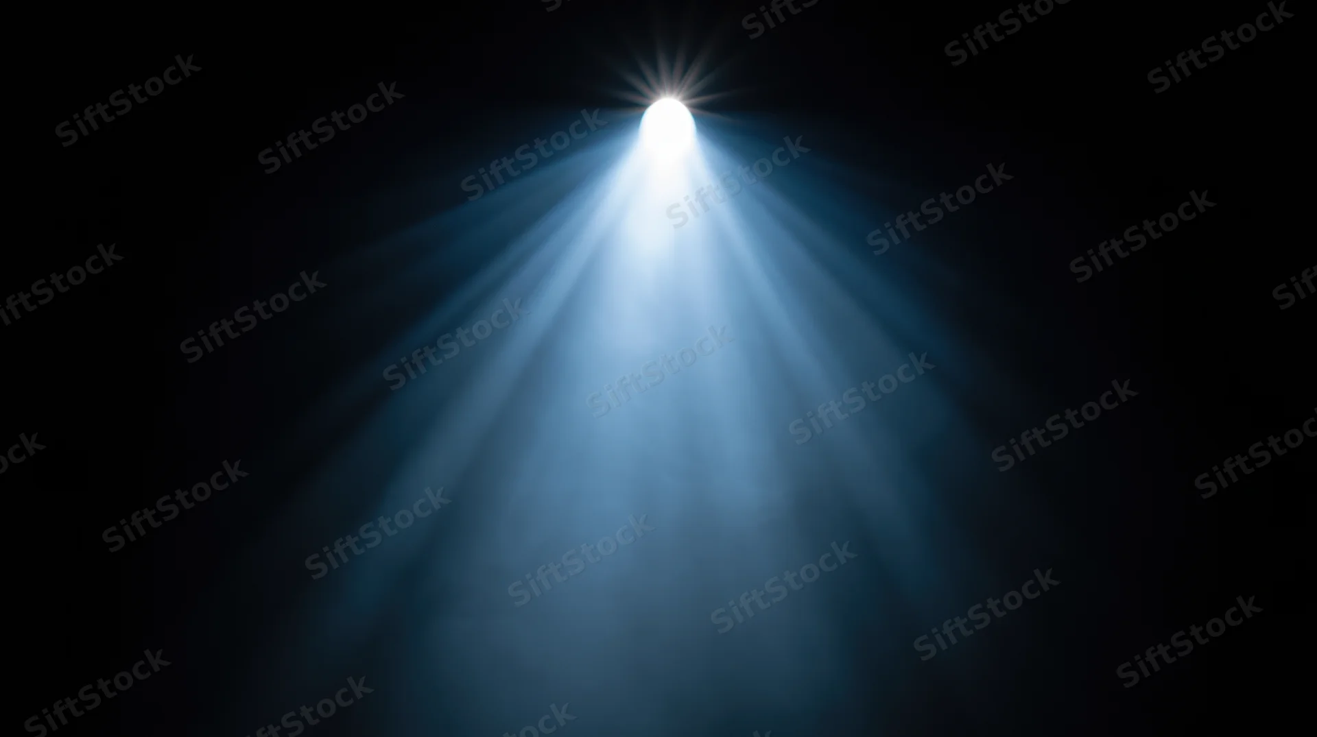 Spotlight beam shining down from above in a dark theater setting