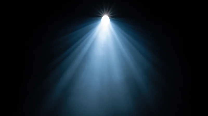 Spotlight beam shining down from above in a dark theater setting