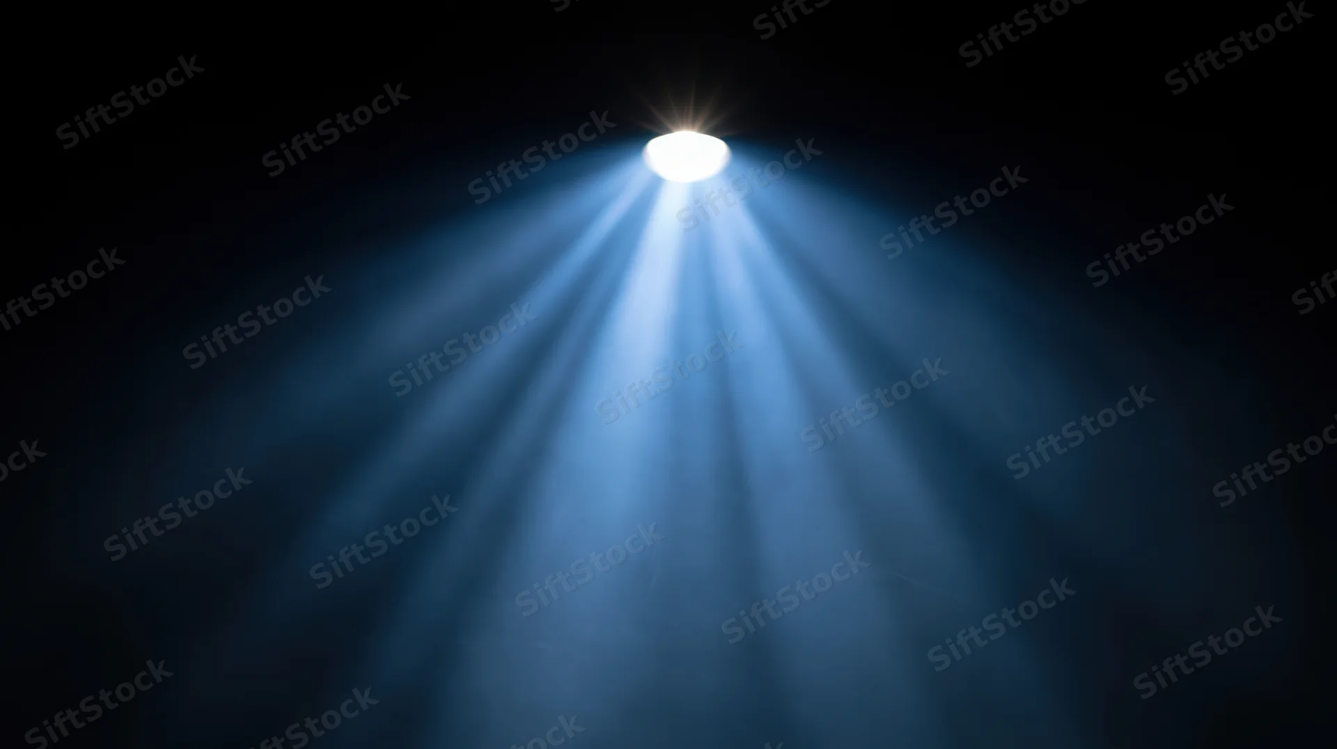 Spotlight beam shining down from above in a dark theater setting
