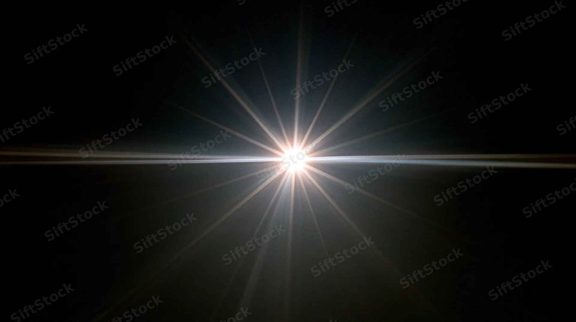 Bright light source emitting starburst rays across dark background