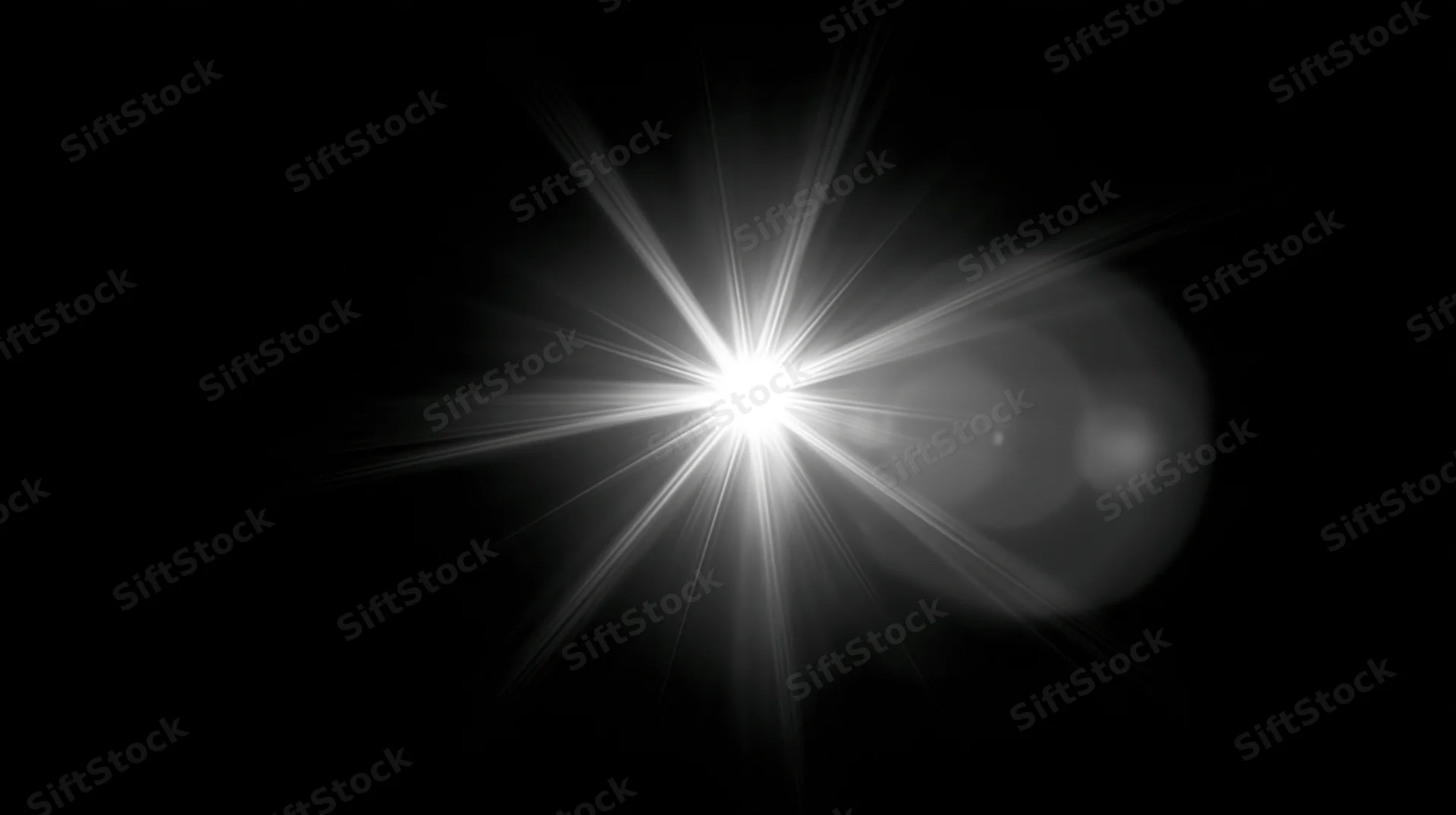 Bright starburst light flare on black background with copyspace