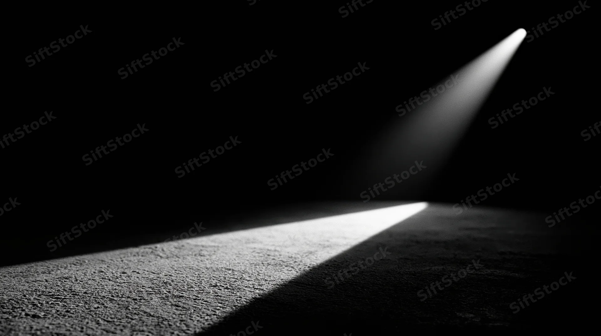 A spotlight beam illuminating a textured carpet in a dark room