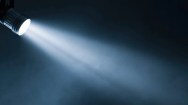 Flashlight emitting a bright beam of light into dark smoky space