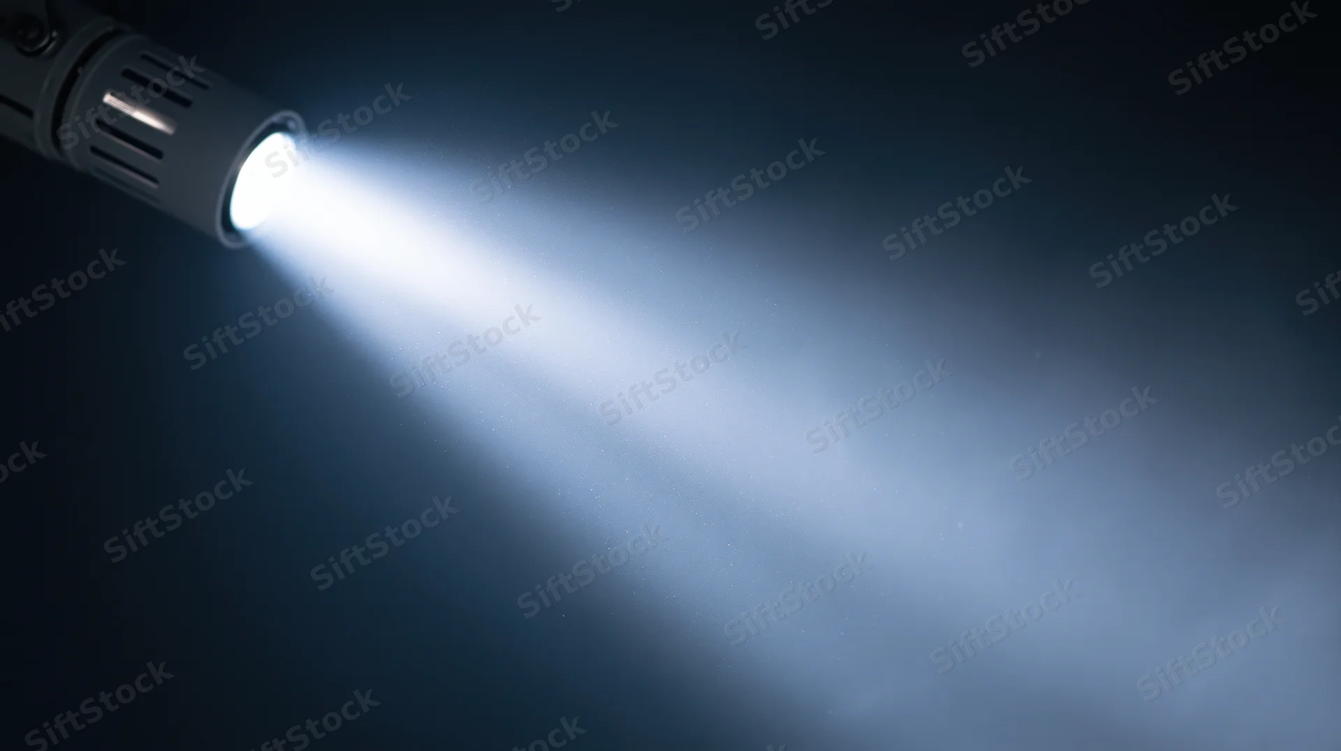 Flashlight emitting bright beam of light in dark environment