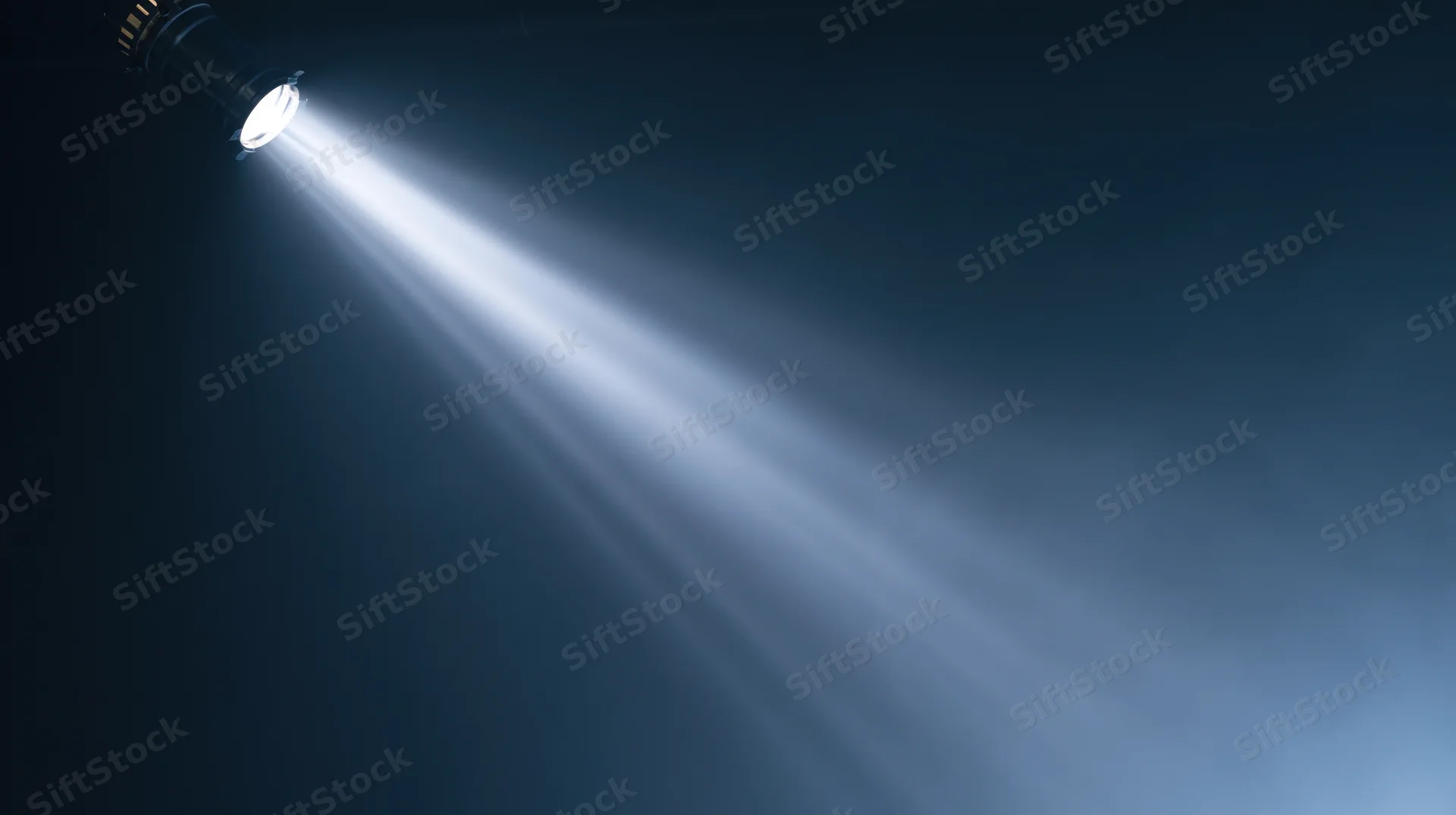 Spotlight beam shining from ceiling in dark theater setting