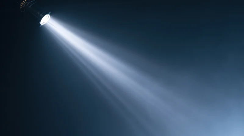 Spotlight beam shining from ceiling in dark theater setting