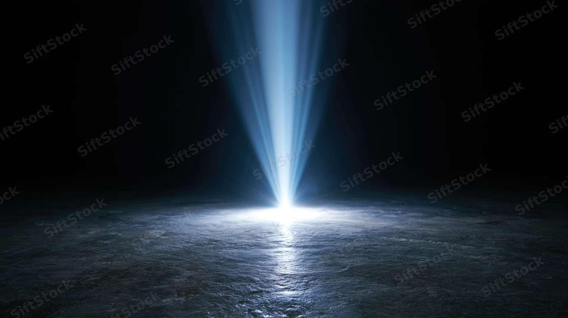 A bright blue light beam shining down onto a dark textured floor, creating a glowing spotlight in the center