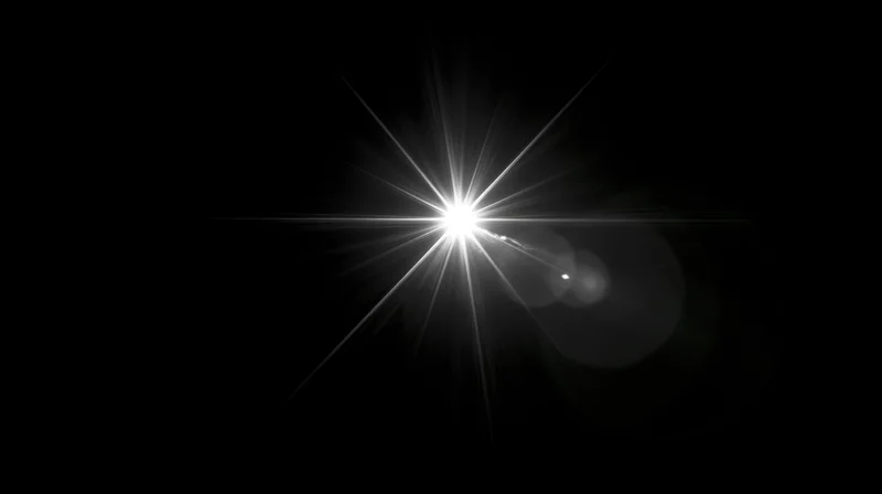 Bright starburst light flare centered on black background with radiating beams and lens flare effect