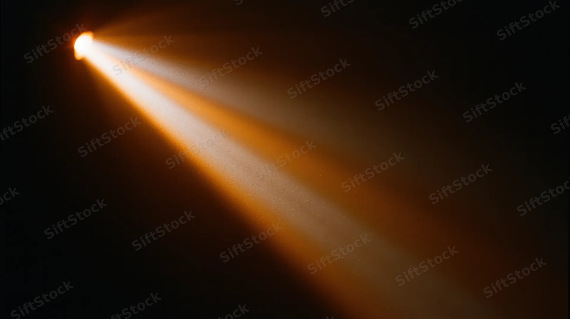 Bright spotlight beam cutting through dark space with warm glow and visible light rays