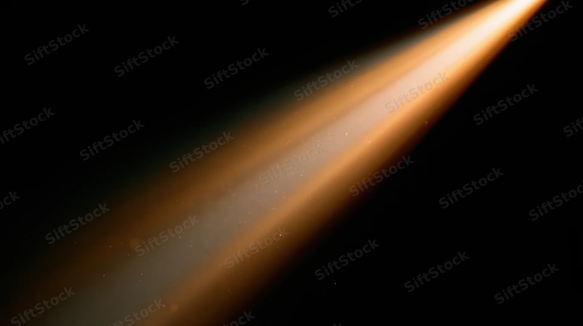 Diagonal beam of warm orange light radiating across dark space with floating particles