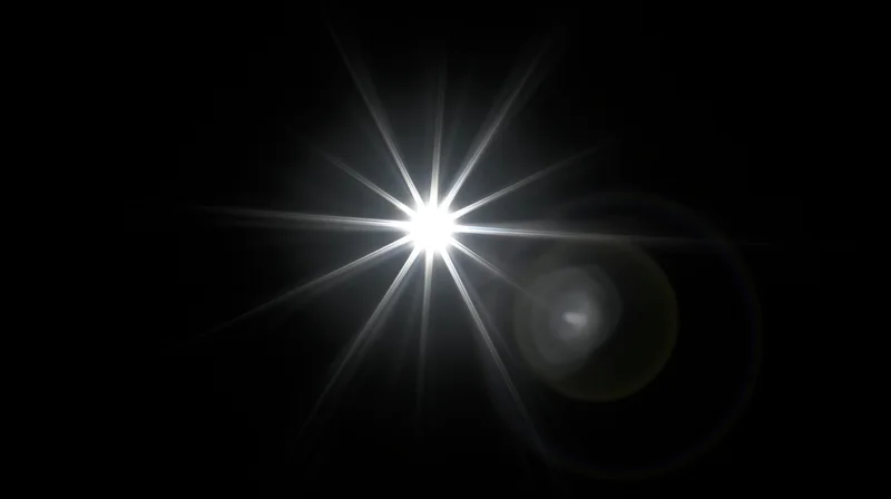 Bright starburst light flare on black background with lens flare and bokeh effect