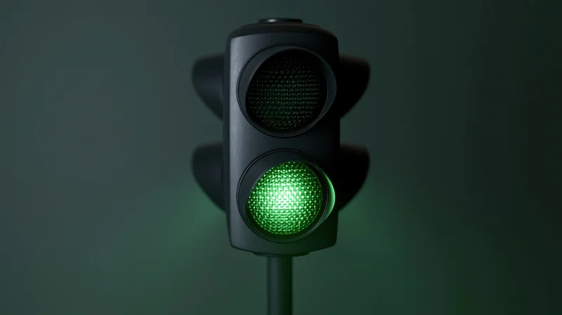 Traffic light with green signal illuminated on dark background
