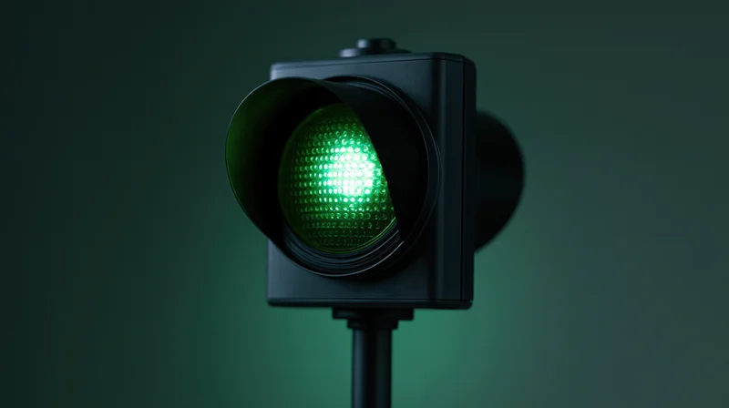 Illuminated green traffic light signal on dark gradient background with copyspace