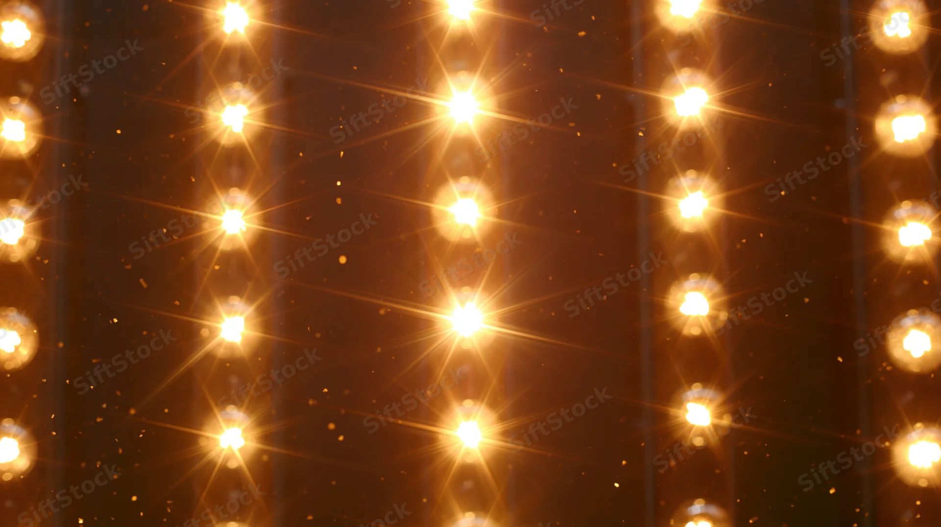 Rows of glowing lightbulbs arranged vertically in a warm golden pattern against a dark background