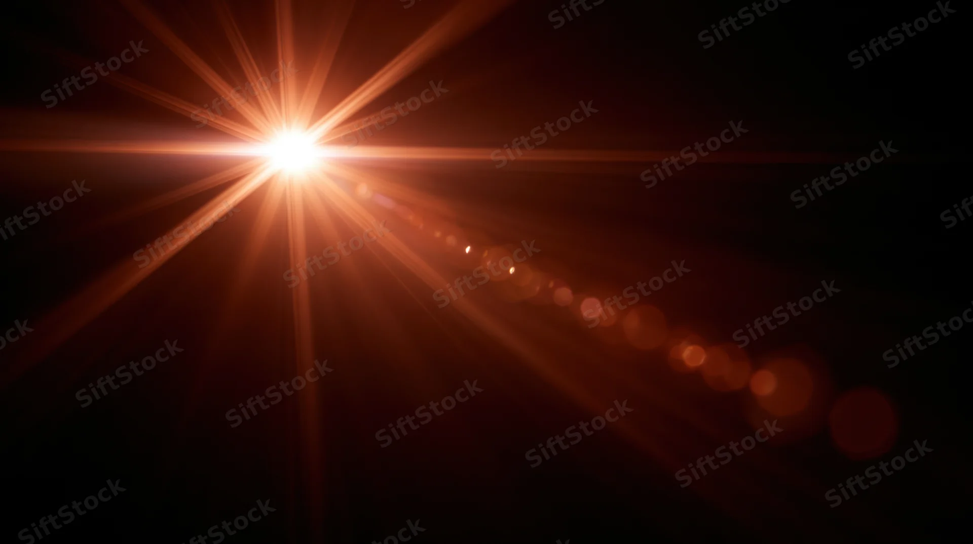 Bright light source emitting starburst rays and bokeh circles against dark background